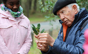 Homme montrant des plantes à une enfant