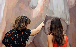 Deux femmes regardant une oeuvre de Street Art